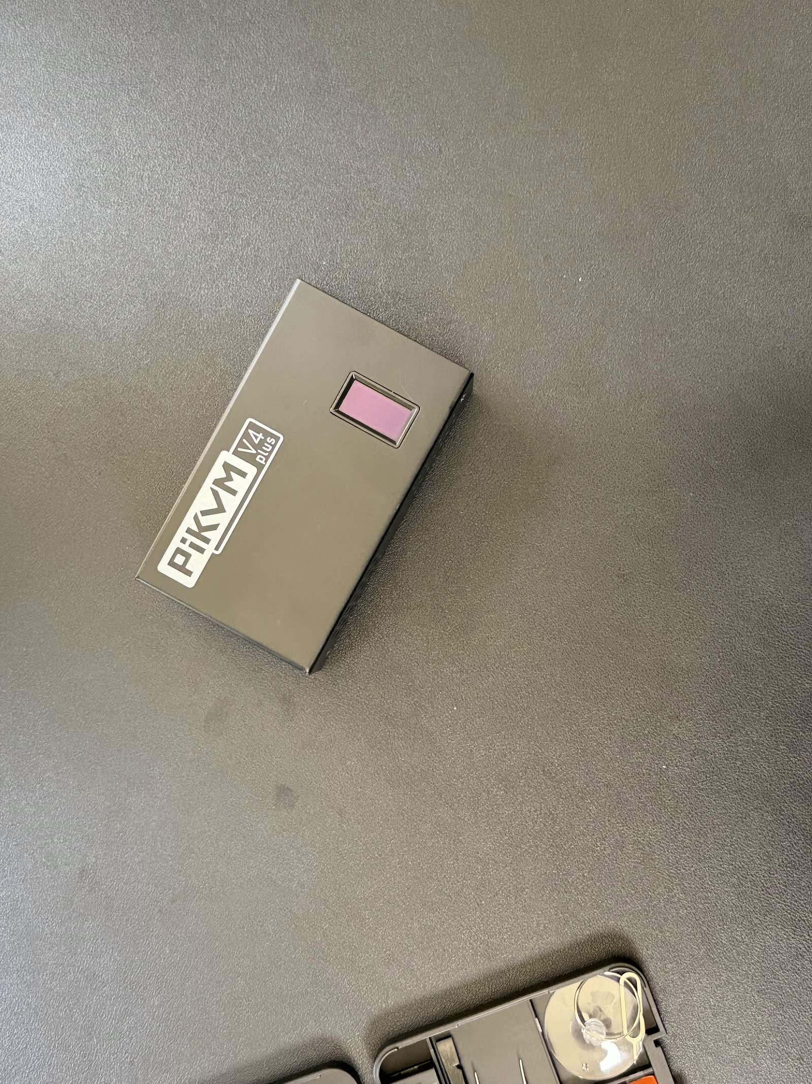 The sealed PiKVM V4 Plus before we opened it, steel enclosure doubling as a heatsink.