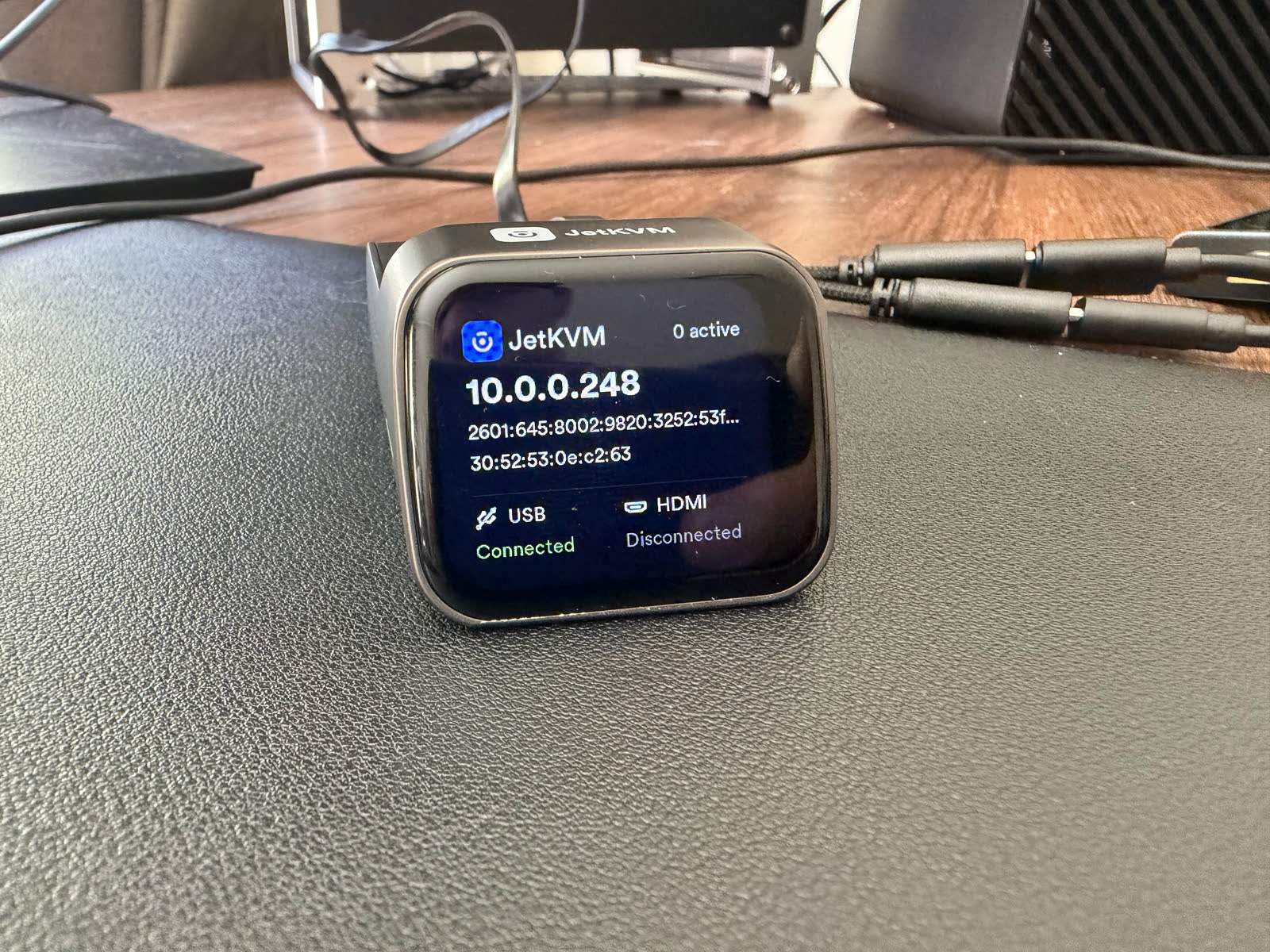 Photo of the JetKVM touchscreen and the NanoKVM Full OLED each displaying the device IP address, the detail that makes both a sub-two-minute setup.
